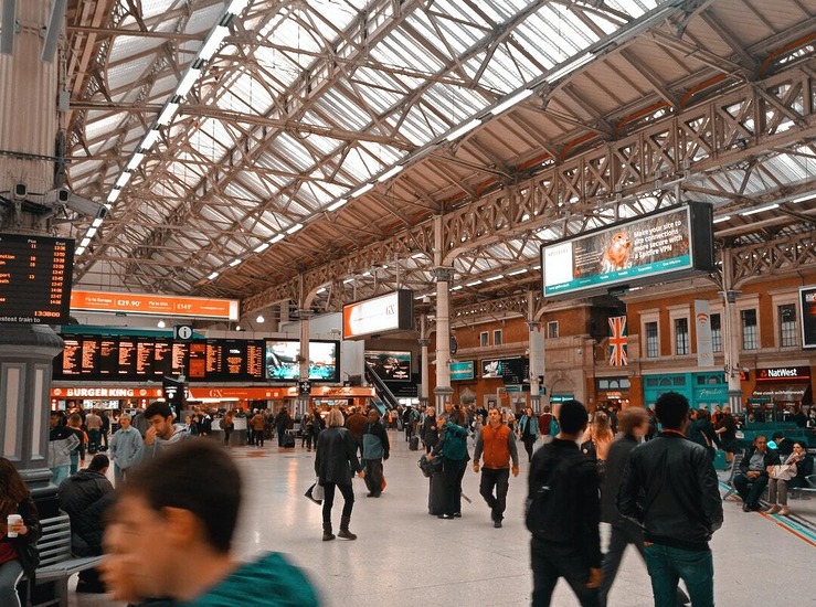 people walking in a train station in london