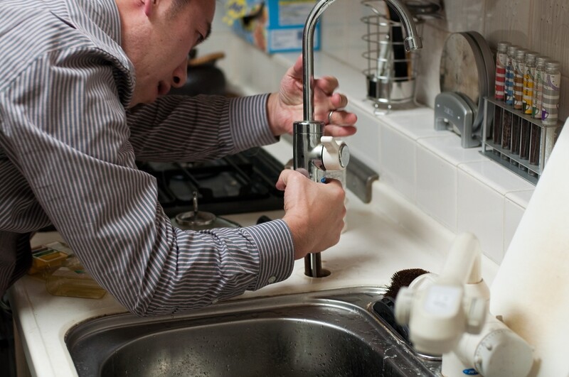 Plumber repairing dishwasher