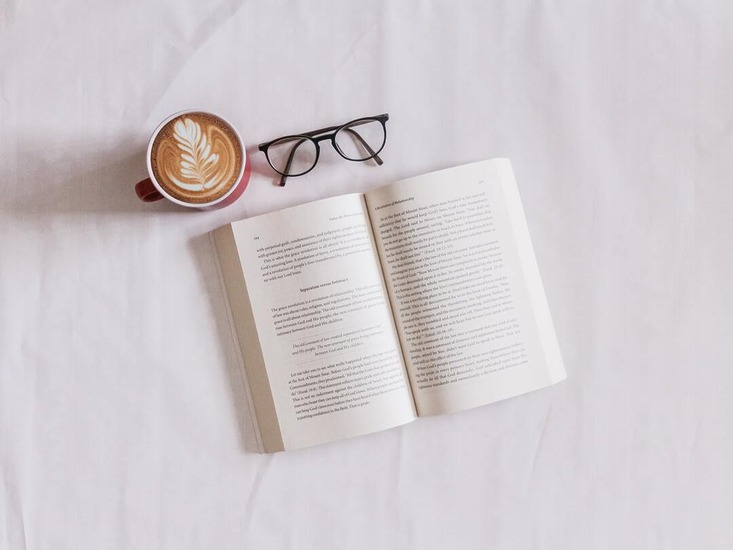 Open book, cup of coffee, glasses